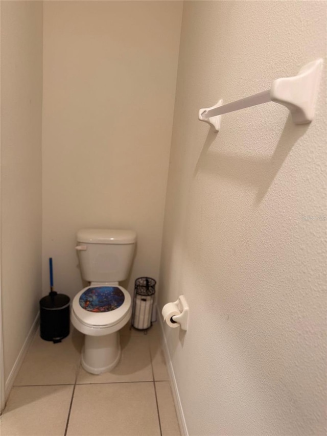 bathroom with tile patterned flooring, toilet, and baseboards