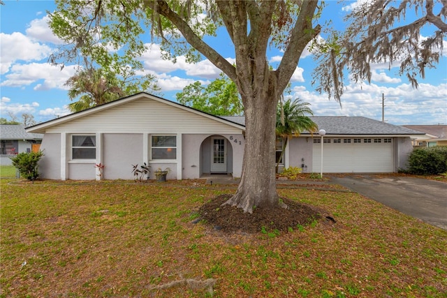 single story home with stucco siding, an attached garage, driveway, and a front yard