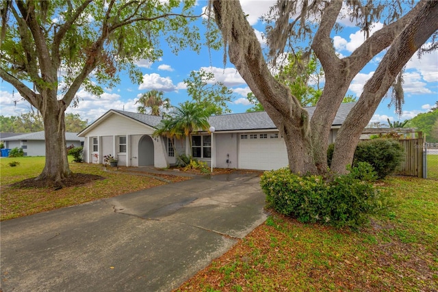 ranch-style house with a shingled roof, a front lawn, stucco siding, driveway, and an attached garage