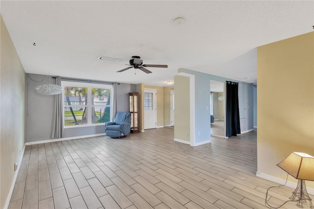 interior space with baseboards, wood finished floors, and a ceiling fan