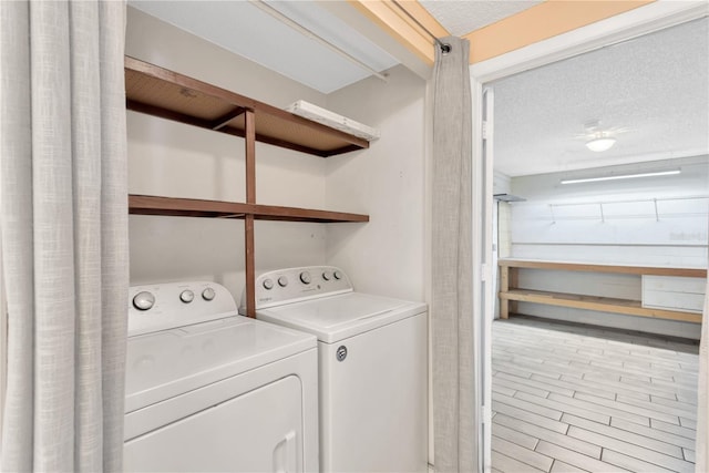 laundry area with separate washer and dryer, laundry area, and a textured ceiling