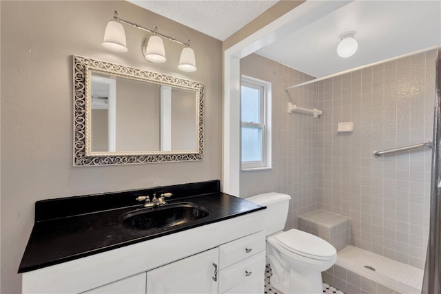 full bath featuring a tile shower, a textured ceiling, toilet, and vanity