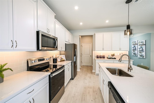 kitchen featuring white cabinets, tasteful backsplash, stainless steel appliances, and a sink