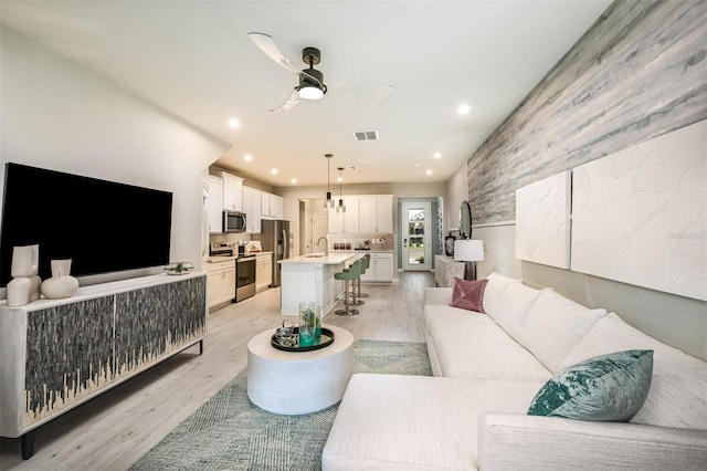 living room with light wood-style floors, recessed lighting, visible vents, and ceiling fan