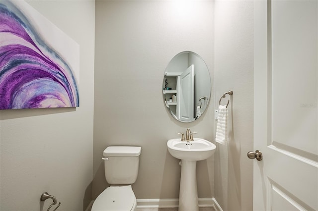 bathroom featuring toilet and baseboards