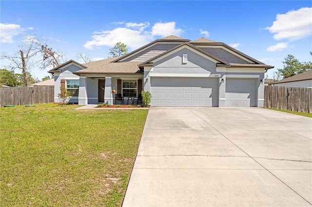 view of front facade with an attached garage, fence, driveway, stucco siding, and a front lawn