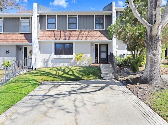 multi unit property featuring a front yard and stucco siding