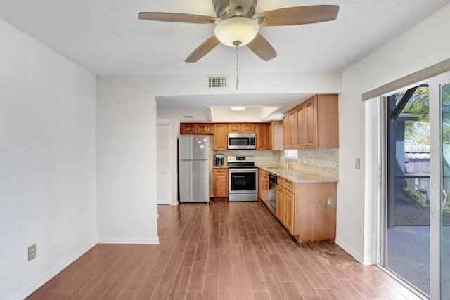 kitchen with light wood finished floors, visible vents, stainless steel appliances, and a sink