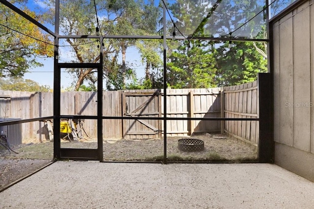 view of gate featuring a fenced backyard, central AC unit, and a patio