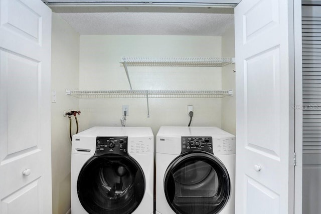 laundry area with a textured ceiling, laundry area, and independent washer and dryer