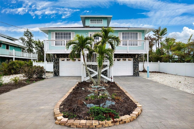 beach home with fence, a garage, and driveway