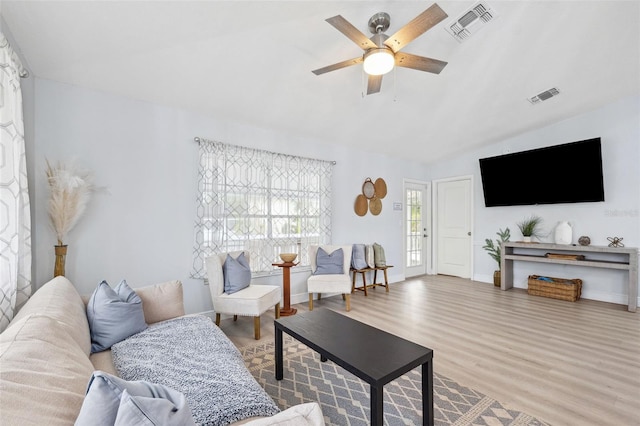 living area with ceiling fan, visible vents, lofted ceiling, and wood finished floors