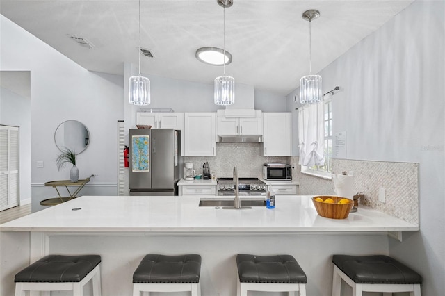 kitchen featuring under cabinet range hood, stainless steel appliances, visible vents, and decorative backsplash