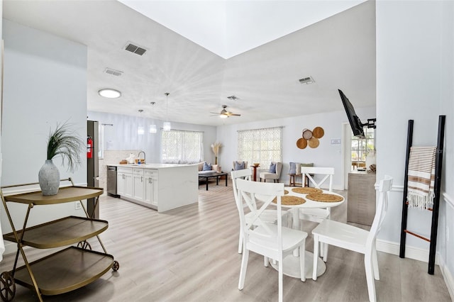 dining room featuring visible vents, light wood-style flooring, baseboards, and ceiling fan