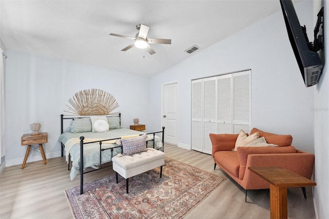 bedroom with visible vents, baseboards, vaulted ceiling, light wood-style flooring, and a closet