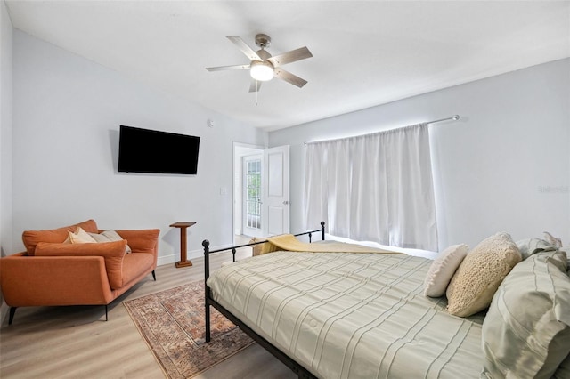 bedroom featuring baseboards, light wood-style floors, and a ceiling fan