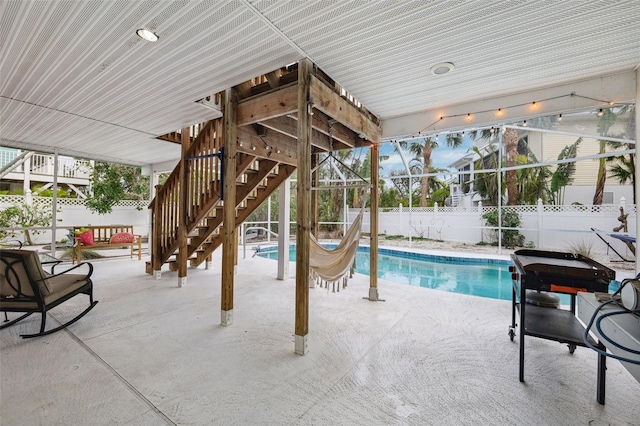 view of pool featuring a patio, stairway, a fenced in pool, a fenced backyard, and a lanai