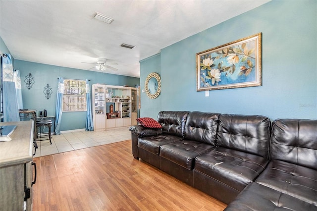 living room with a ceiling fan, wood finished floors, visible vents, and baseboards