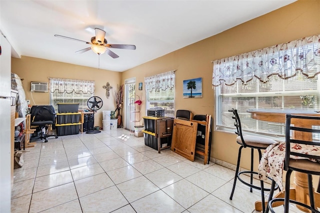 office featuring light tile patterned floors, baseboards, a wall mounted AC, and a ceiling fan