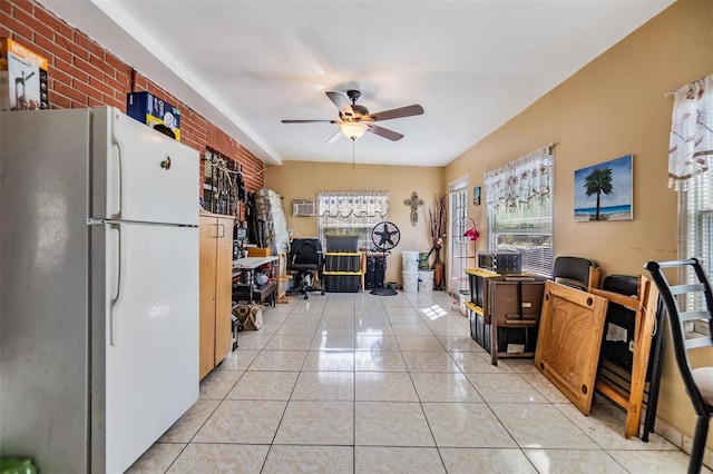 kitchen featuring light tile patterned flooring, a wall mounted air conditioner, freestanding refrigerator, and a ceiling fan