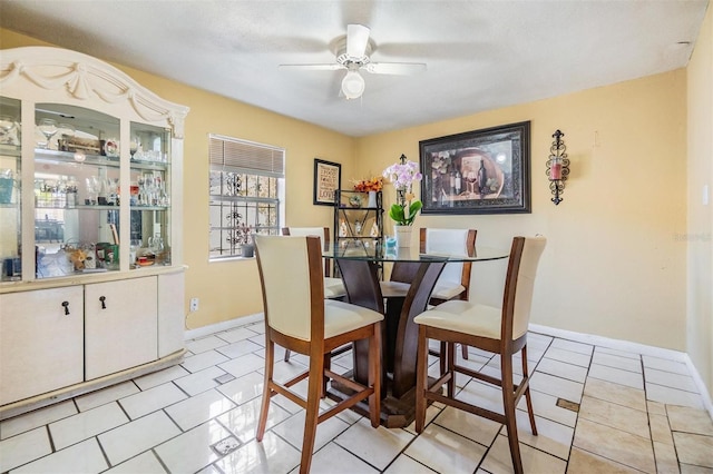 dining space featuring light tile patterned floors, baseboards, and a ceiling fan