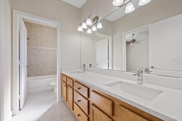 full bathroom featuring double vanity, a sink, toilet, and a ceiling fan