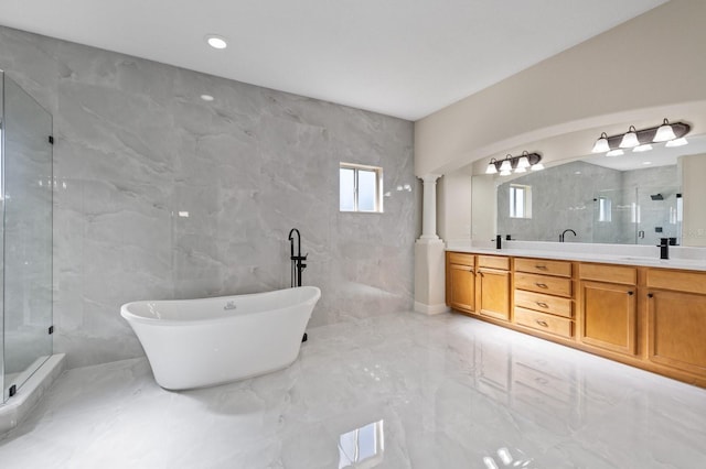 bathroom with a sink, marble finish floor, a shower stall, double vanity, and decorative columns