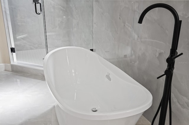 interior details featuring a freestanding tub and a shower stall