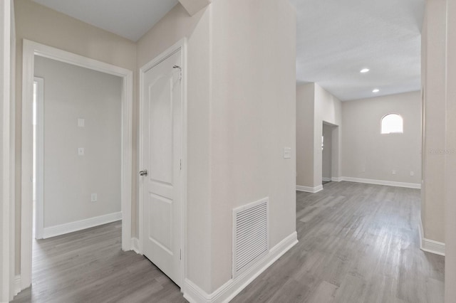 corridor featuring baseboards, visible vents, wood finished floors, and recessed lighting