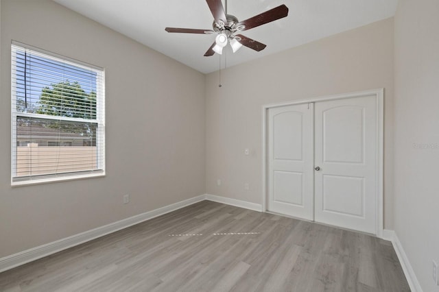 unfurnished bedroom featuring light wood-style floors, a closet, ceiling fan, and baseboards