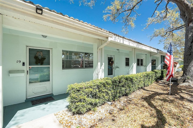 view of exterior entry with stucco siding