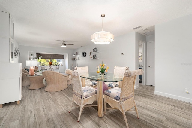 dining space with ceiling fan, light wood finished floors, visible vents, and baseboards