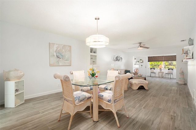 dining room with light wood-type flooring, ceiling fan, and baseboards