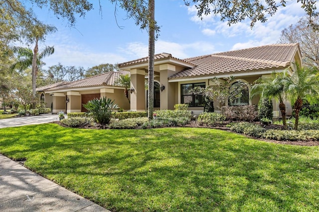 mediterranean / spanish-style home featuring a tile roof, stucco siding, concrete driveway, an attached garage, and a front yard