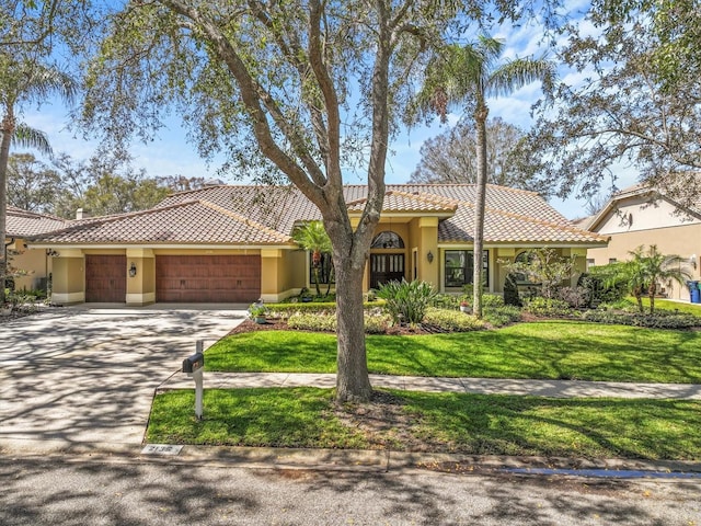 mediterranean / spanish-style home with a front lawn, a tile roof, an attached garage, and stucco siding