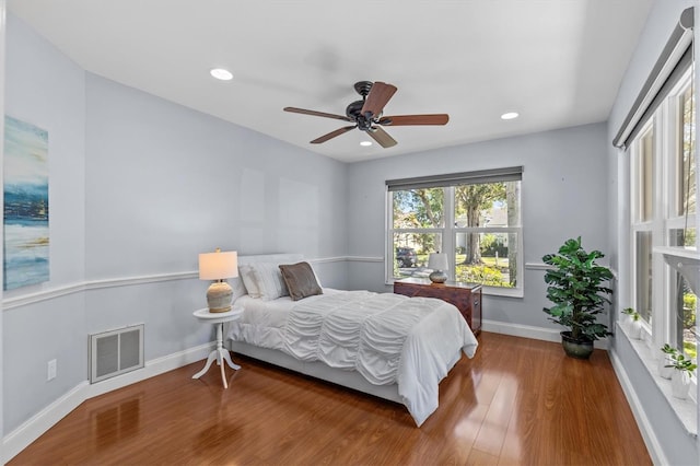 bedroom with recessed lighting, wood finished floors, visible vents, and baseboards