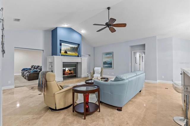 living room featuring ceiling fan, baseboards, vaulted ceiling, marble finish floor, and a glass covered fireplace