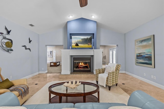 living area featuring a glass covered fireplace, visible vents, lofted ceiling, and baseboards