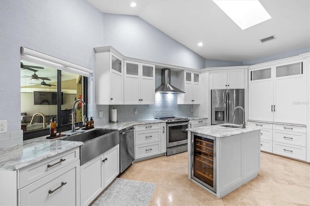 kitchen with wall chimney exhaust hood, stainless steel appliances, a sink, and beverage cooler