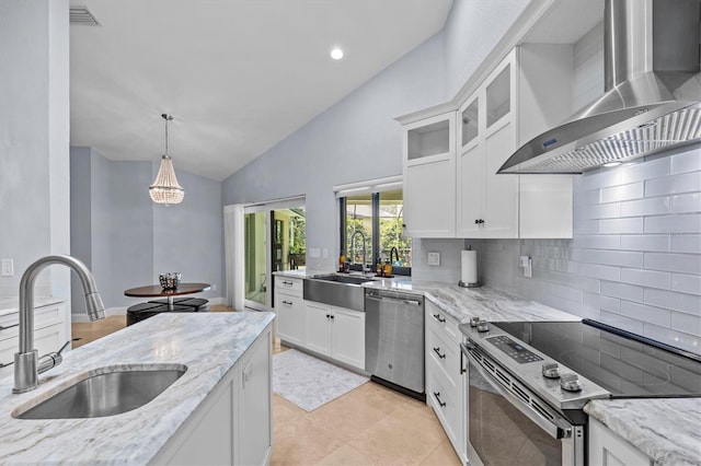 kitchen featuring stainless steel appliances, a sink, wall chimney exhaust hood, and light stone countertops