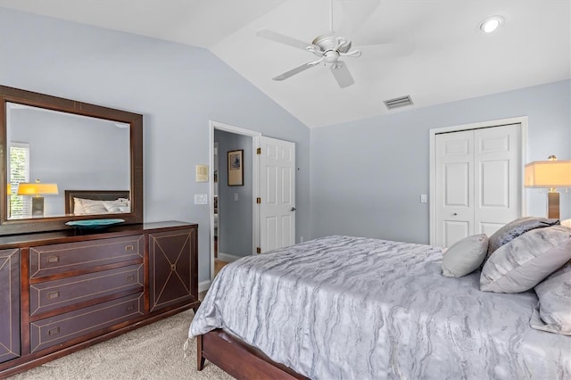 bedroom featuring a closet, visible vents, a ceiling fan, light carpet, and vaulted ceiling