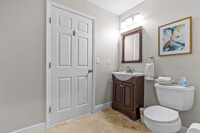 bathroom with baseboards, vanity, toilet, and tile patterned floors