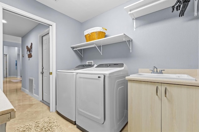 laundry area with laundry area, separate washer and dryer, a sink, and visible vents