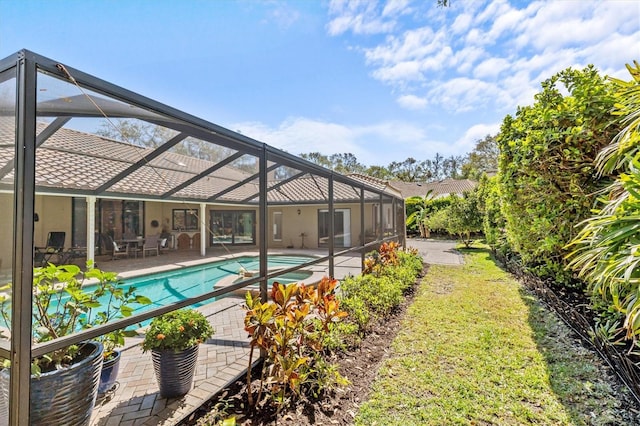 outdoor pool featuring a patio and glass enclosure