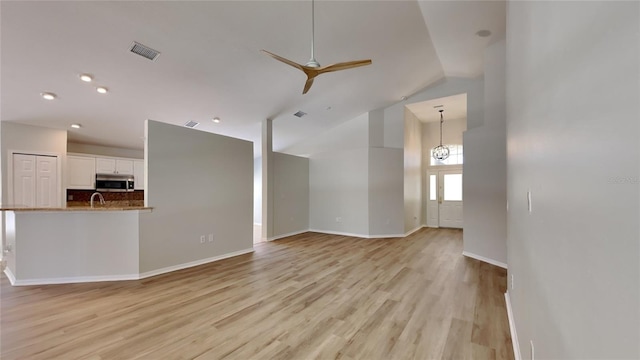 unfurnished living room with visible vents, baseboards, light wood-style floors, and a ceiling fan