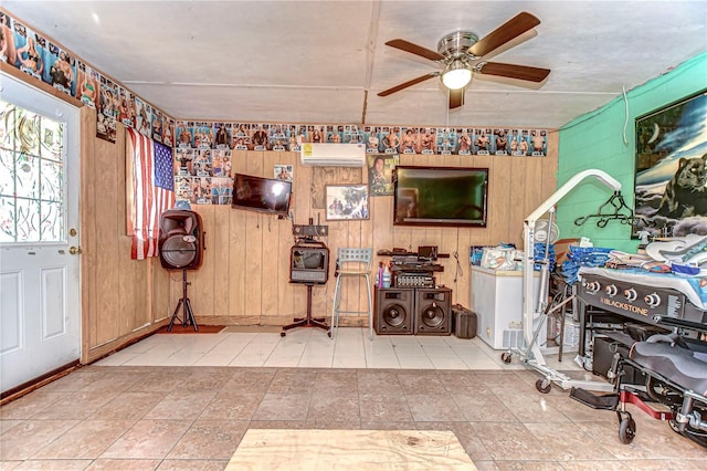 interior space with a ceiling fan, a wall unit AC, and wooden walls