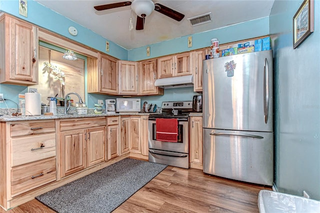 kitchen with visible vents, light wood-style flooring, appliances with stainless steel finishes, light brown cabinets, and under cabinet range hood