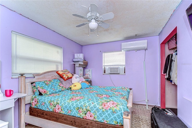 bedroom featuring a wall unit AC, a textured ceiling, a ceiling fan, and cooling unit