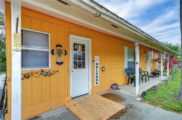 view of exterior entry featuring covered porch