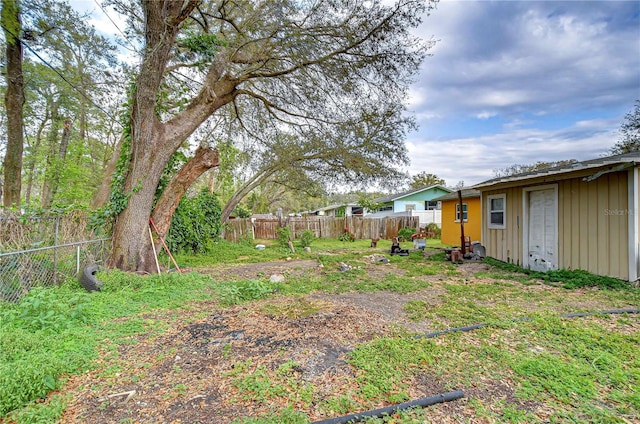 view of yard featuring an outdoor structure and fence